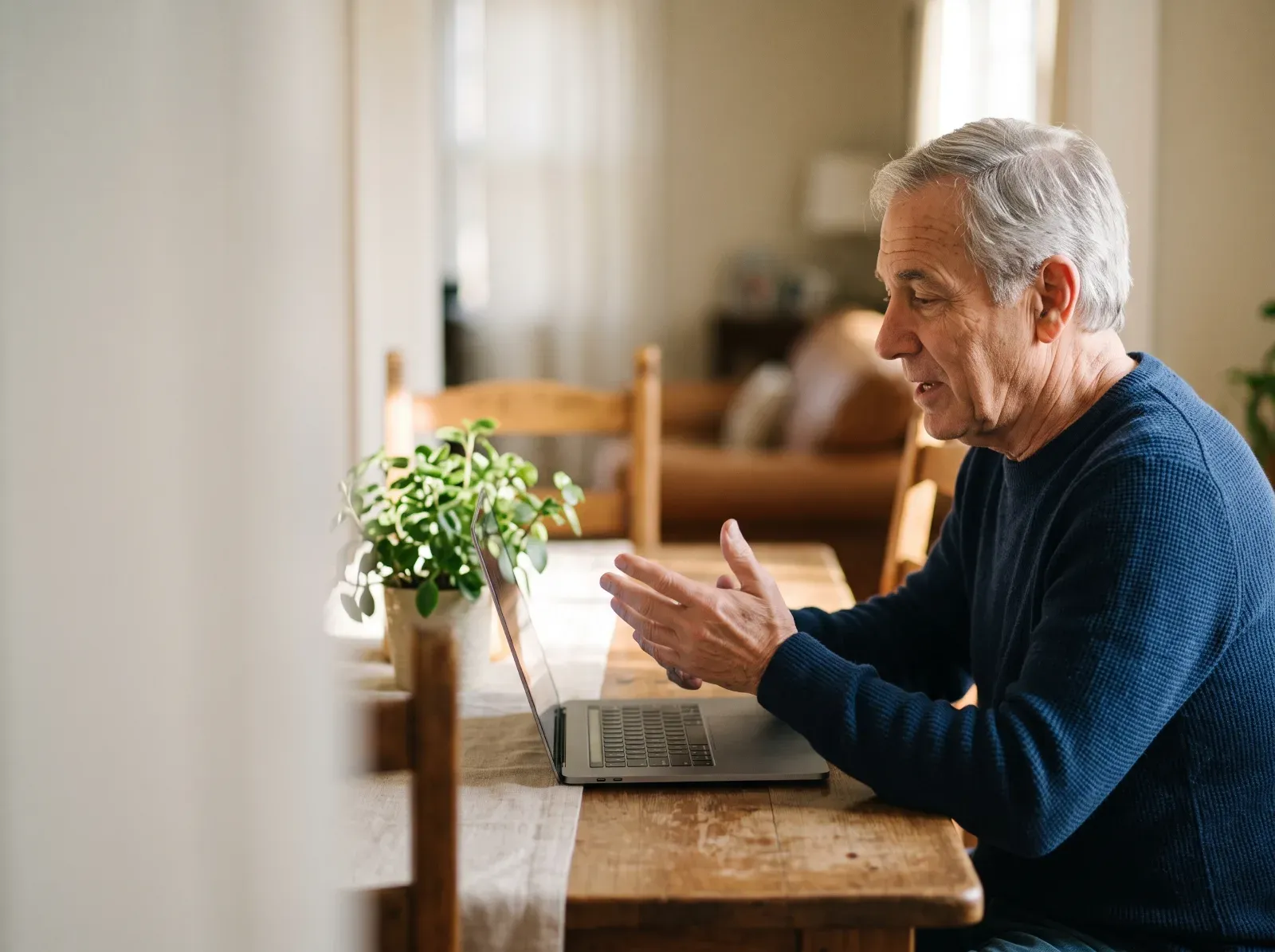 A man speaking on a video call from his dining table